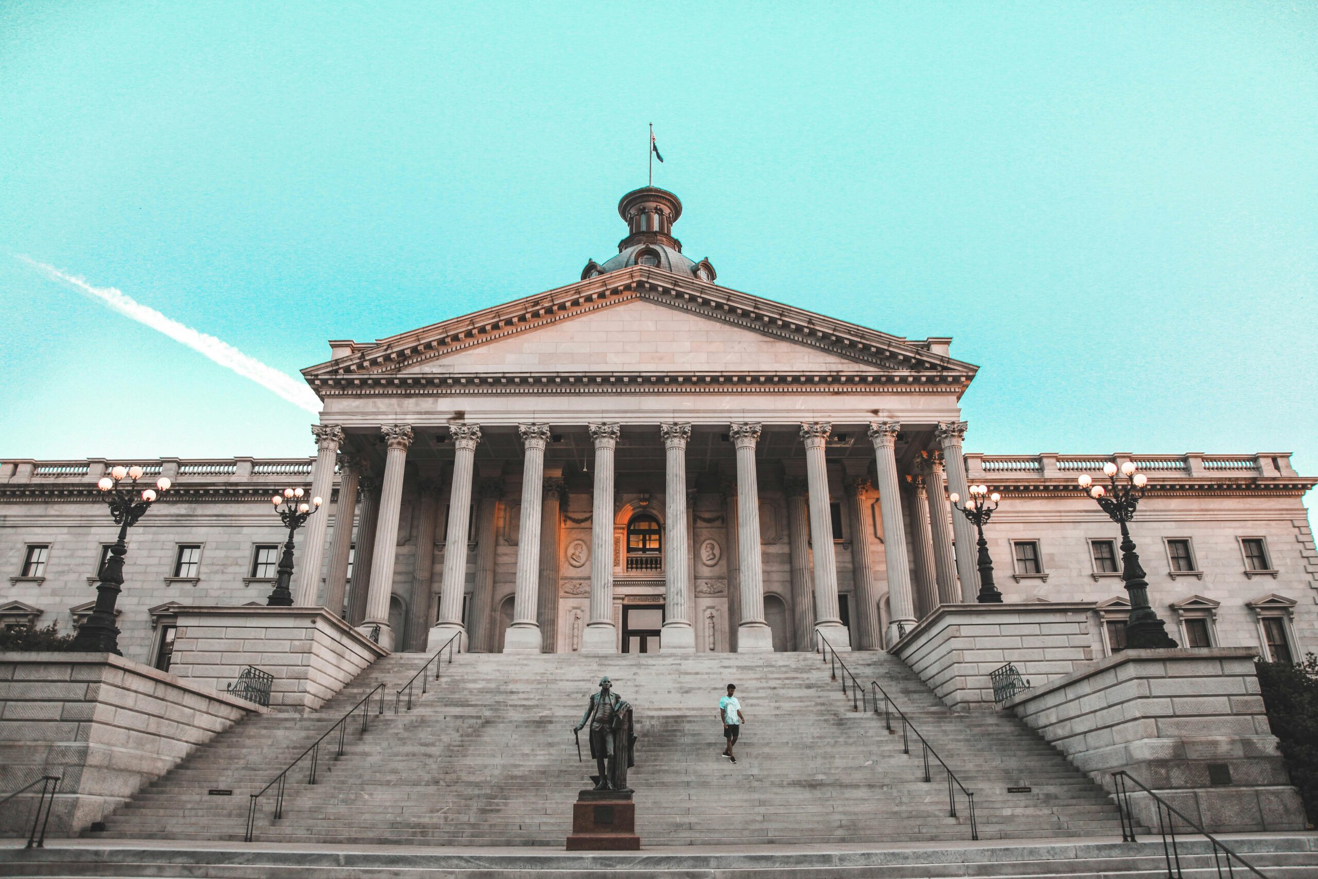 Striking view of the South Carolina State House with its grand steps and clear blue sky backdrop.