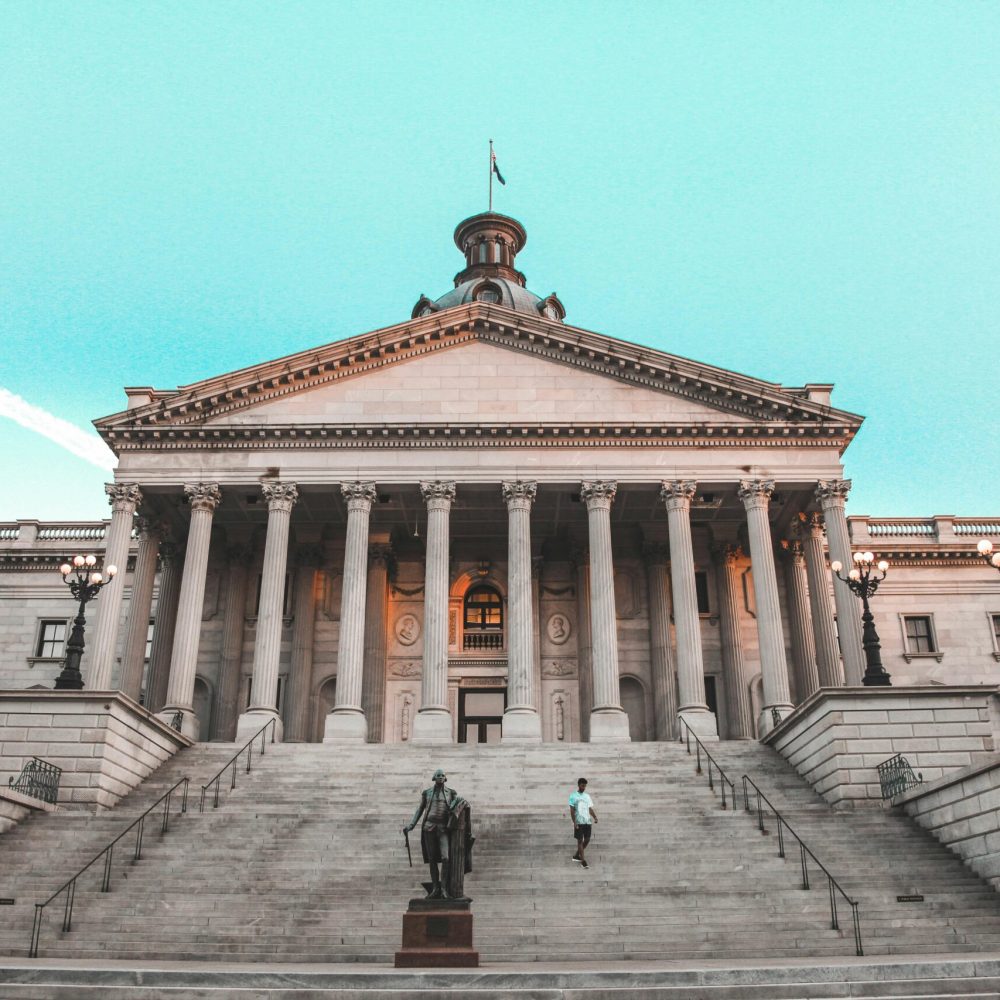 Striking view of the South Carolina State House with its grand steps and clear blue sky backdrop.